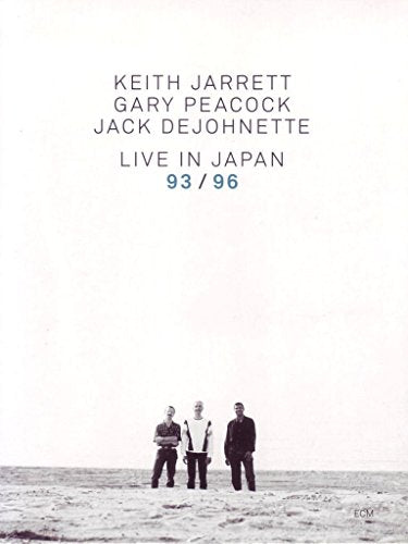 A DVD cover featuring three men standing on a beach with a minimalist background.