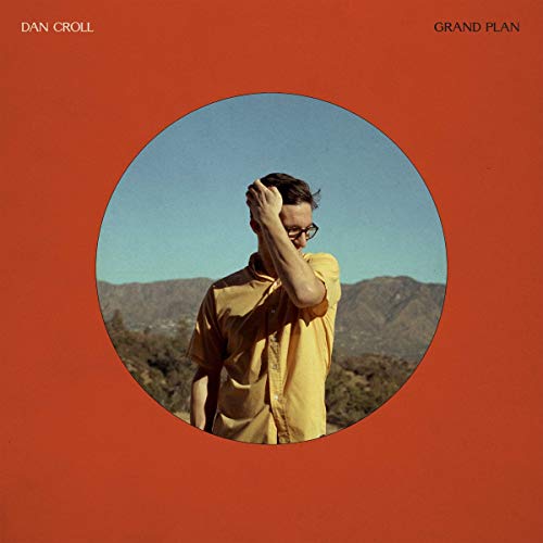 "Album cover with man in yellow shirt on burnt orange background."
