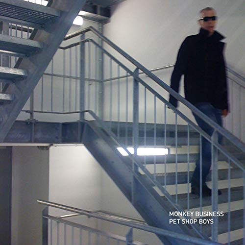 A man in dark clothing walks down a metal staircase, with text "Pet Shop Boys" and "Monkey Business".