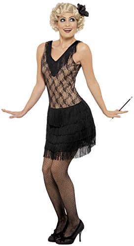 Woman in 1920s flapper costume, black dress, fishnets, and heels, holding a cigarette holder.