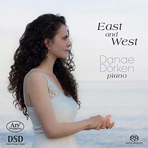 "CD cover featuring a woman in white dress with curly hair, standing by water."