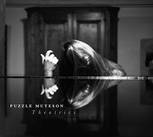 "Black and white album cover with a woman's reflection in a dark room."