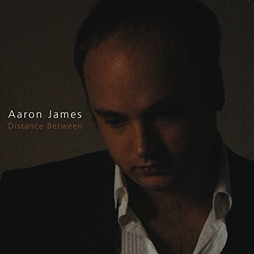 Album cover featuring a man in a suit, partially shadowed, with text "Aaron James Distance Between".