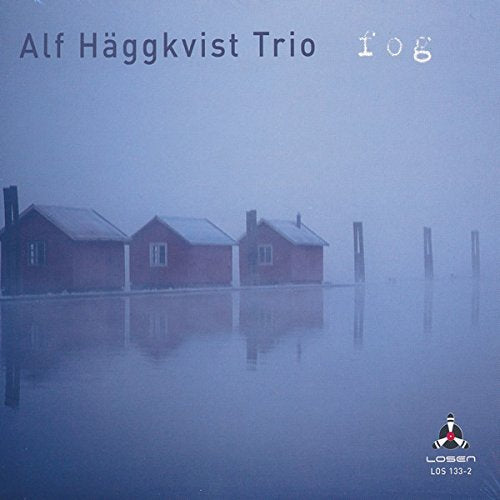 Album cover: foggy scene with three red houses reflected in water, misty background.