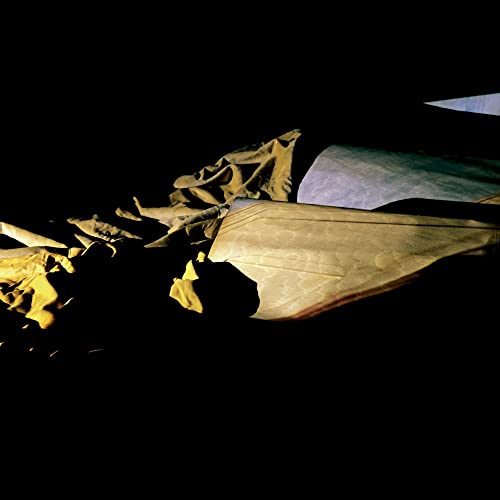 Dark, abstract album cover with folded paper and yellow highlights.