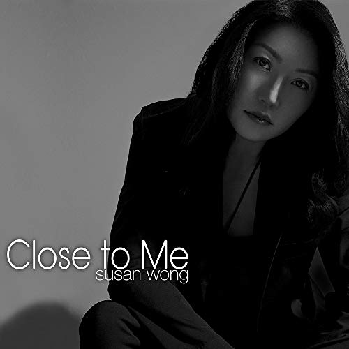 Black and white album cover with a woman in a dark outfit.