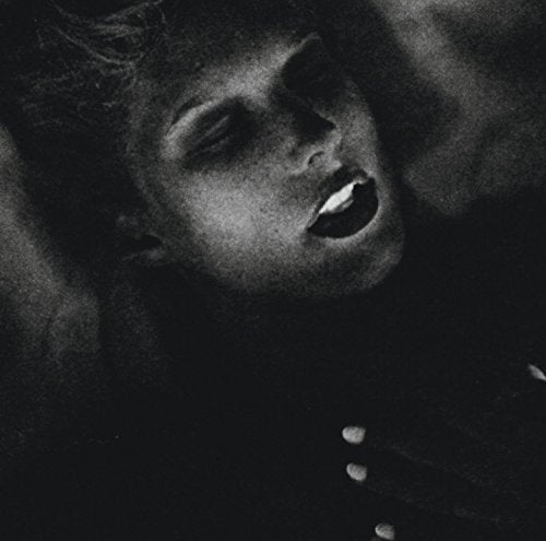 The alt text for the image is: "Black and white close-up of a woman's face, looking up."