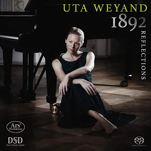 "CD cover featuring a woman sitting beside a grand piano, wearing a dark dress."