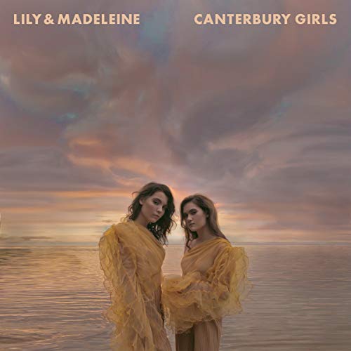 "Album cover featuring two women in yellow dresses standing together by calm water."