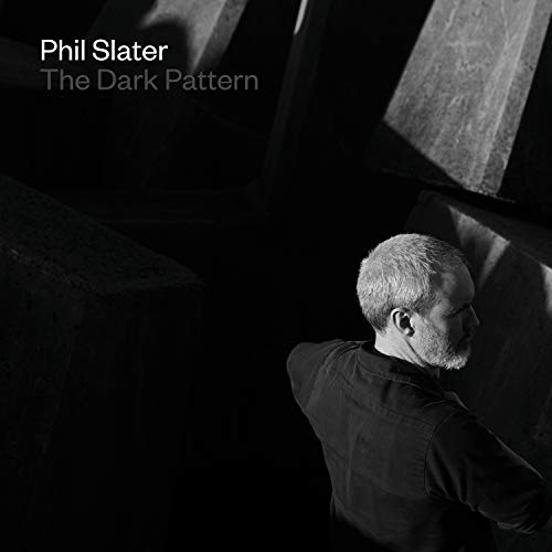 Album cover: black-and-white image of a man with short hair in a dark space.