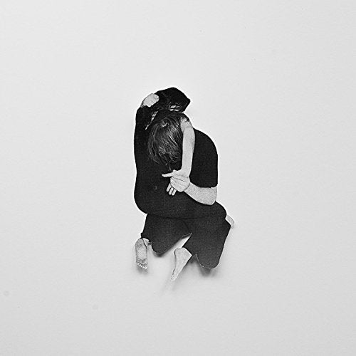 A black and white image of a man and woman embracing, with a plain background.