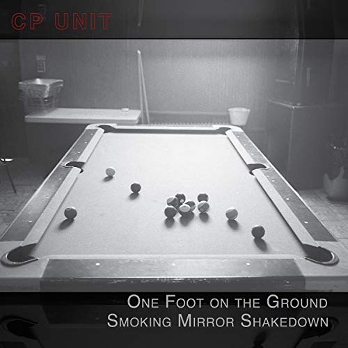 Black-and-white image of a pool table with scattered balls in a dimly lit room.