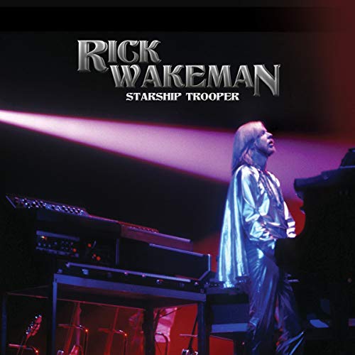 Rick Wakeman on stage with keyboards, under purple and red lighting, on album cover.