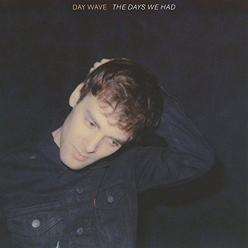 "Album cover with a young man in a dark shirt against a dark background."