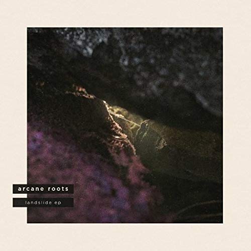 The image depicts a dark, blurry landscape with a light beam. #### Alt text: "Dark landscape with a beam of light, 'arcane roots landslide ep' text."