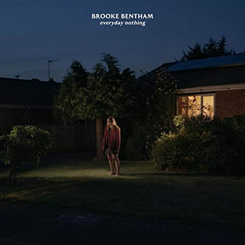 Vinyl album cover featuring a woman standing alone in a dimly lit yard.