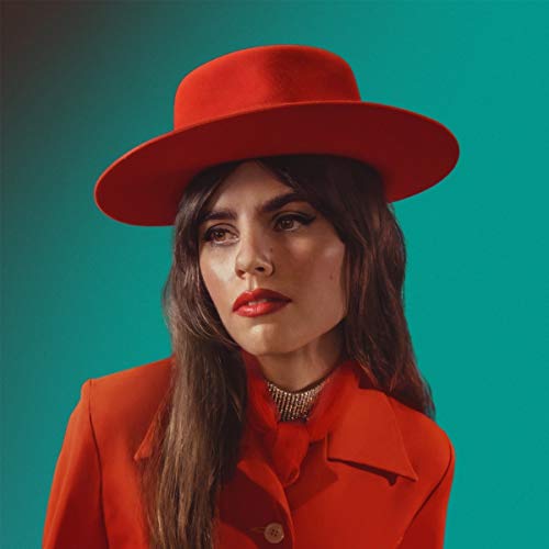 Woman in red hat and jacket against a teal background.