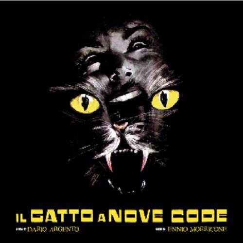 "Black cat's face with yellow eyes and sharp fangs on a black background."