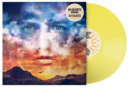 Yellow vinyl record with album cover featuring a face in cloudy sky.