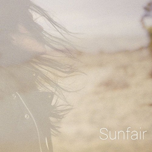 A faded image of a woman with long hair blowing in the wind, with "Sunfair" text.
