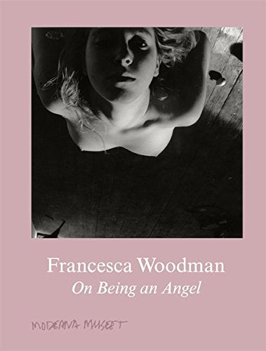 Pink book cover with black-and-white photo of a woman on a wooden floor.