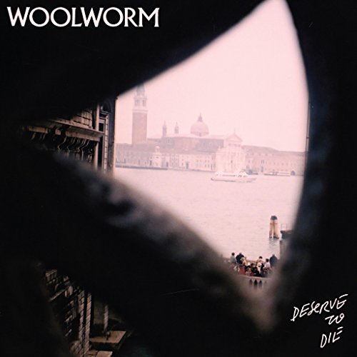 Album cover with a view of a city skyline through a hole.