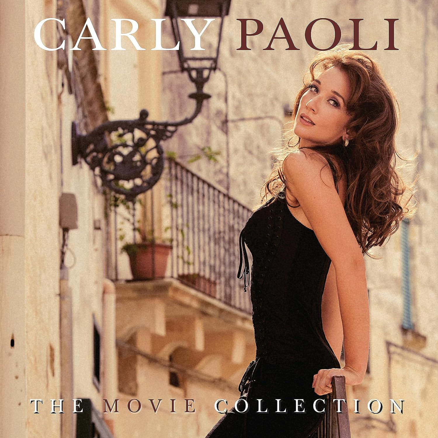 "Album cover featuring a woman in a black dress on a balcony."