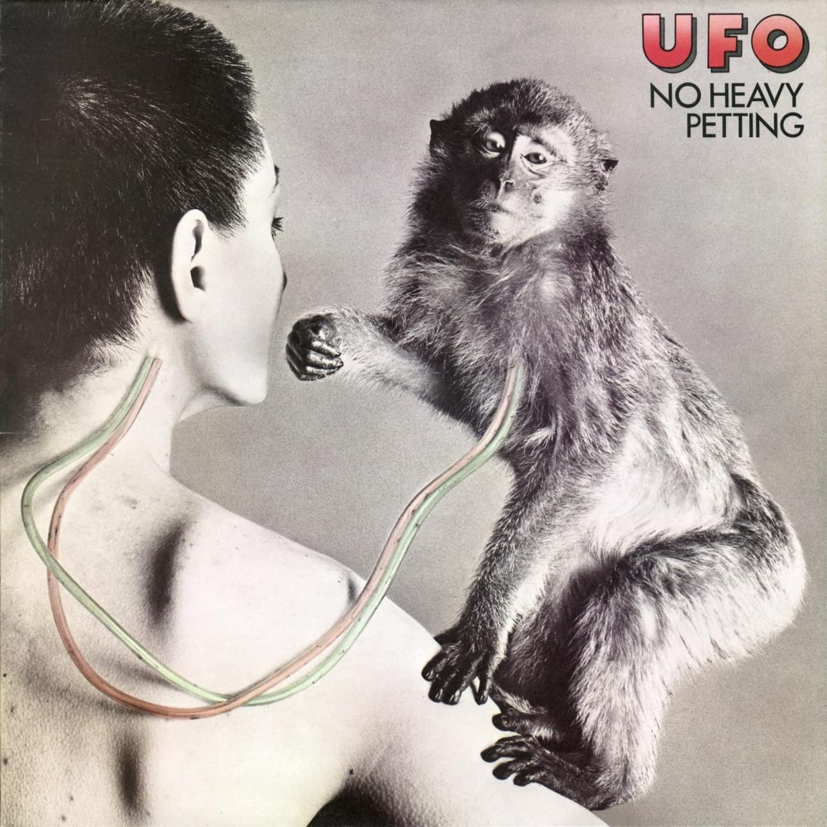 "Album cover with a man and monkey connected by wires, 'UFO No Heavy Petting'."