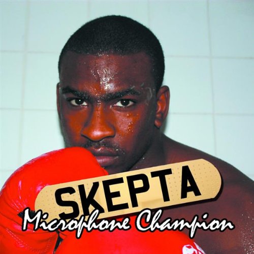 Man wearing red boxing gloves with "SKEPTA" on them, in front of a tiled wall.