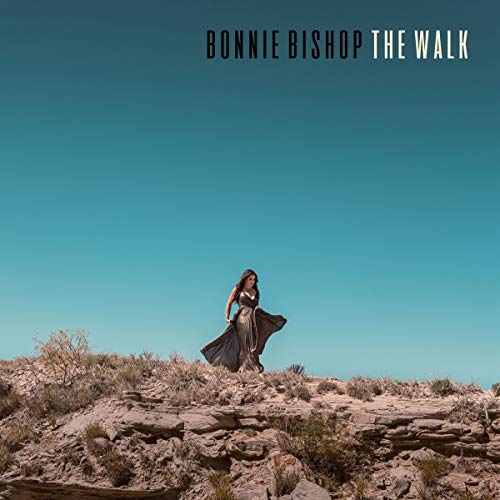 Vinyl album cover featuring a woman in a flowing dress on a rocky outcrop.