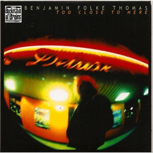 "Album cover with a man standing under a diner's neon sign at night."