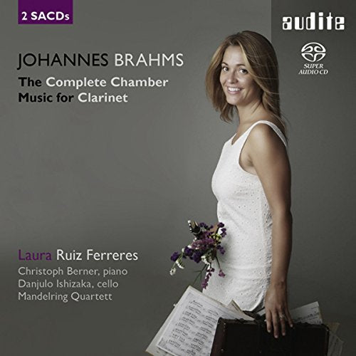 CD cover featuring a woman holding flowers and sheet music, gray background.