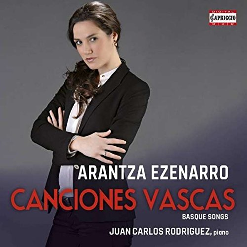 CD cover featuring a woman in a black suit with crossed arms against a gray background.