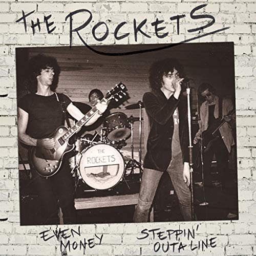 Vinyl record cover with black-and-white band photo on a brick background.