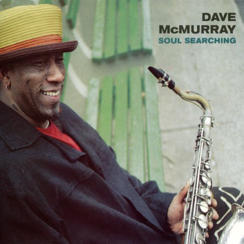"Album cover with man holding saxophone, wearing yellow hat, against green wooden background."