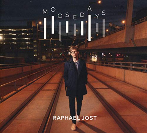 "Album cover featuring a man standing on train tracks at night with cityscape behind."