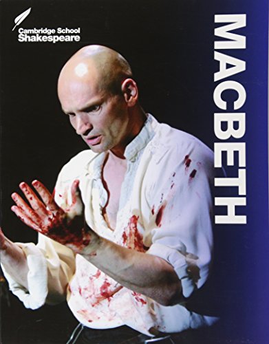 A man with a bald head and blood-stained white shirt, hands outstretched.