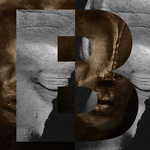 The image is a close-up of a large, metallic "B" on a textured surface. For accessibility purposes, a suitable alt text could be: "A large metallic letter B on a rough, stone-like background."