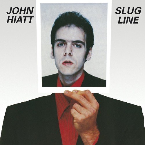 "Album cover with a man holding a photo of himself as a younger man."