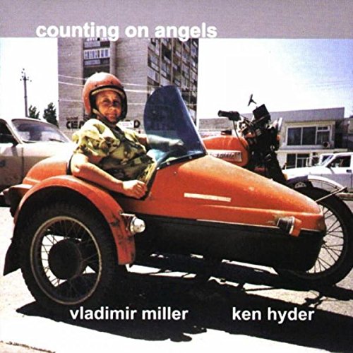 "CD cover featuring a child in a red motorcycle sidecar, with city background."