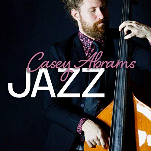 Man in a dark suit holding a double bass, with "Casey Abrams JAZZ" text overlay.