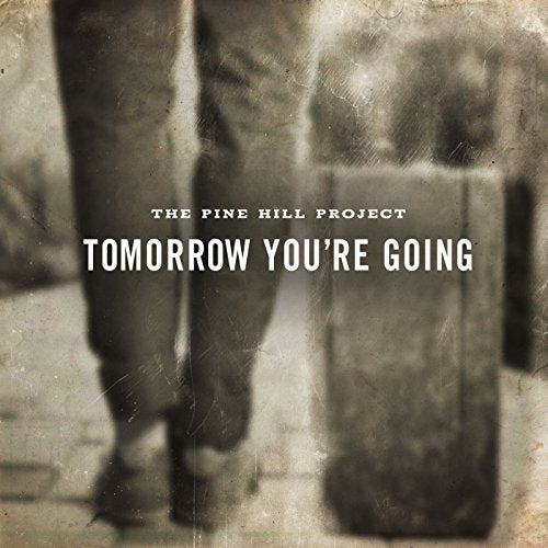 Sepia-toned album cover with a person walking, carrying a suitcase, and white text overlay.