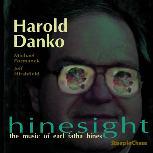 "Album cover with a man's face and reflective glasses, featuring colorful text and names."
