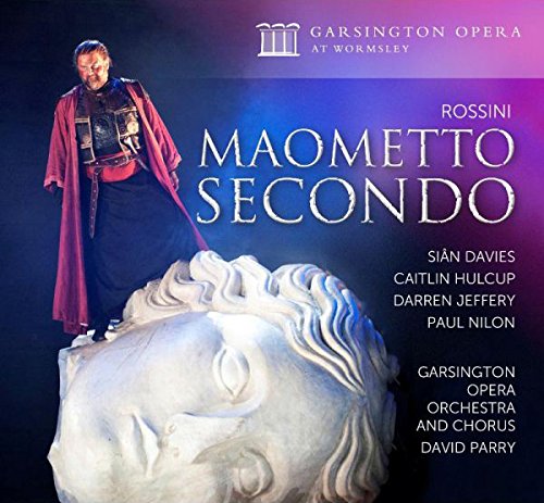 "Album cover with man standing on a marble head sculpture, opera title and performers' names."