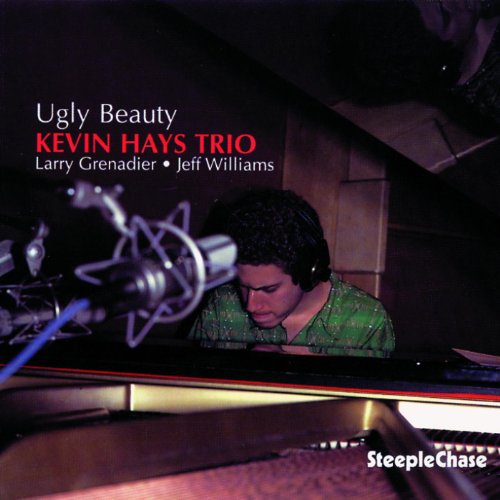 "Album cover featuring a man wearing headphones, playing piano in a dimly lit studio."