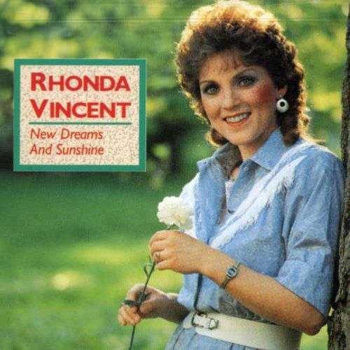 "CD cover featuring a smiling woman holding a white flower, outdoors."