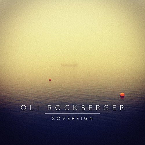 "Album cover with foggy sea scene, red buoys, and artist name 'Oli Rockberger'."