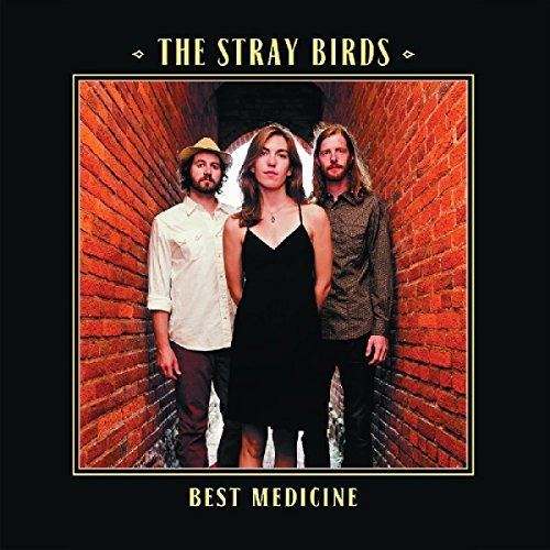 The image is a vinyl record cover with three people standing in a brick passageway.