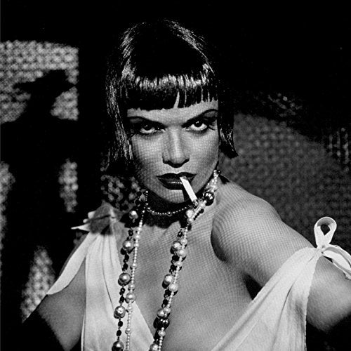 Black and white image of a woman smoking a cigarette, wearing a white dress.