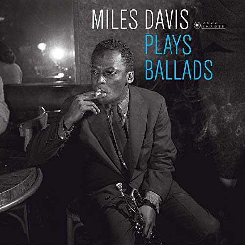 "Black and white vinyl album cover featuring Miles Davis holding a trumpet, smoking."
